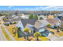 Beautiful elevated view of a brick home with a well-manicured lawn and lake view at 2385 Windmill Way, Myrtle Beach, SC 29579