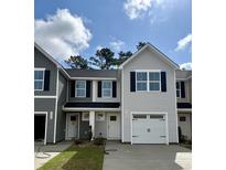 New two-story townhome showcasing charming curb appeal with a one car garage and neutral color palette at 265 Christiana Ln. # E, Myrtle Beach, SC 29579