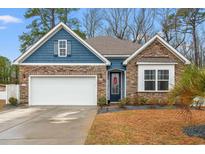 Charming single Gathering home with stone accents, blue siding, and a well manicured lawn at 414 Antietam Place, Little River, SC 29566