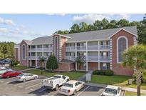 A charming condo complex with brick accents, white trim balconies, lush landscaping and ample parking at 4826 Innisbrook Ct. # 902, Myrtle Beach, SC 29579