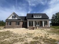 New brick home featuring a welcoming front porch with white columns and a classic, symmetrical design under a bright sky at 713 Horry Rd., Conway, SC 29526
