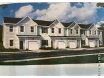 Newly built light gray townhomes with black roofs offer modern living spaces and attached garages at 1145 Windy Grove Ln Sw # 16, Ocean Isle Beach, NC 28469