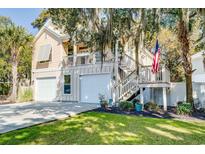 Charming home with a two-car garage, an American flag, and a staircase to the elevated front porch at 15 Flaggpoint Ln., Murrells Inlet, SC 29576