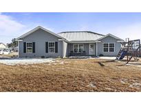 Charming one-story home with gray siding, black shutters and front yard with sparse grass and some snow at 1801 Heirloom Dr., Conway, SC 29527