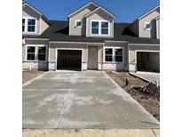 New two-story townhome featuring an attached garage and a concrete driveway, ready for its new owners at 2034 Wild Indigo Circle Nw # 206, Calabash, NC 28467