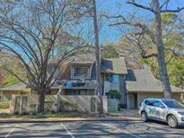 Inviting townhouse features classic siding, a roof with a chimney, and is surrounded by mature trees in a quiet neighborhood at 301 Myrtlewood Ct. # 17-E, Myrtle Beach, SC 29572