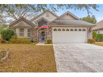 Charming home with a brick facade, a two-car garage, a well-maintained lawn, and an American flag proudly displayed at 3103 Robyn Ct., Little River, SC 29566