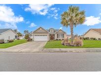 Charming single-story home boasting a well-manicured lawn, attached garage, and beautiful landscaping at 401 Oak Crest Circle, Longs, SC 29568