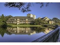 Scenic waterfront condo complex with lush landscaping and bridge reflected in the water at 410 Melrose Pl. # 304, Myrtle Beach, SC 29572