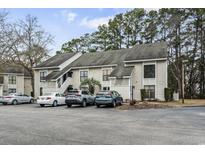 Well-maintained condo complex exterior with ample parking and mature trees, offering a comfortable and convenient living environment at 4502 Little River Inn Ln. # 2507, Little River, SC 29566