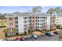 A multi-story condo building displays a detailed facade and well-maintained landscaping at 4882 Luster Leaf Circle # 305, Myrtle Beach, SC 29577