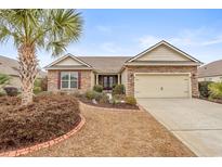 Charming single-story home featuring a stone facade, manicured landscaping, and a well-maintained lawn at 5230 Piemonte Ln., Myrtle Beach, SC 29579