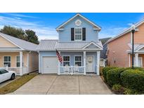 Charming light blue two-story home featuring a cozy front porch and an attached single-car garage at 709 Shell Creek Circle # 709, North Myrtle Beach, SC 29582