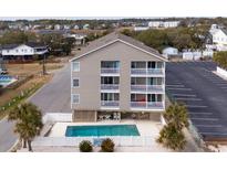 Three story beach house features private balconies and a private pool surrounded by a white fence at 903 N Waccamaw Dr. # 201, Murrells Inlet, SC 29576