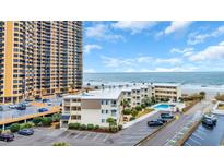 Exterior view of the condo and parking lot near the ocean with clear blue skies at 9620 Shore Dr. # C101, Myrtle Beach, SC 29572