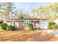 Charming brick home featuring green shutters and a well-maintained front yard with mature trees at 1105 Scott Dr., Myrtle Beach, SC 29577