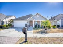 Charming single-story home with a well-manicured lawn, cozy front porch, and attached two-car garage at 1537 Beaumont Way, Myrtle Beach, SC 29577