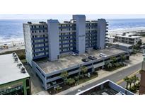 Multi-story building with a parking deck near the beach, featuring blue and gray accents at 1709 S Ocean Blvd. # 411, North Myrtle Beach, SC 29582