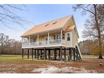 Inviting raised beach home boasts a spacious porch and unique architectural design at 202 Cypress Knee Ct., Conway, SC 29526