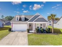 Charming single-story home featuring a well-manicured lawn, a two-car garage, and a welcoming front porch at 2051 Lindrick Ct., Calabash, NC 28467