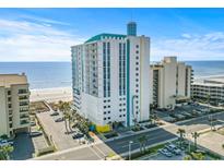 A high-rise condominium building boasts an oceanfront location with beach views and palm trees at 2301 S Ocean Blvd. # 1401, North Myrtle Beach, SC 29582