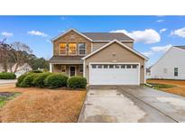 Charming two-story home with a brick and vinyl exterior, a two-car garage, and manicured landscaping at 233 Carolina Farms Blvd., Myrtle Beach, SC 29579