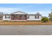 Charming single-story home with a screened porch and well-maintained lawn on a sunny day at 287 Kanawha Trail, Longs, SC 29568