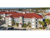 Beautiful condo building with red roof, beige siding, and white balconies overlooking the marina at 4220 Coquina Harbour Dr. # B-12, Little River, SC 29566