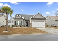 Charming home with a two-car garage, manicured lawn, and a welcoming front entrance at 453 Rycola Circle, Surfside Beach, SC 29575