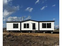 New manufactured home featuring white siding, black trim, and steps leading to the front door at 495 N Green Sea Rd., Loris, SC 29569