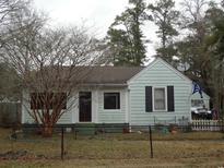 Charming single story home featuring light blue siding, black shutters, and a cozy front yard with mature tree at 606 Dawson St., Georgetown, SC 29440