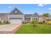 Charming home featuring a well-manicured lawn, a pergola over the garage, and delightful landscaping with palm trees at 641 Indigo Bay Circle, Myrtle Beach, SC 29579