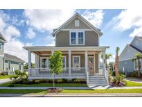 Charming two-story home featuring a welcoming front porch with white columns and manicured landscaping at 8156 Living Tide Dr., Myrtle Beach, SC 29572