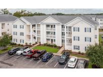 Three-story condo building with white siding, blue shutters and a well-manicured lawn at 901 West Port Dr. # 1807, North Myrtle Beach, SC 29582