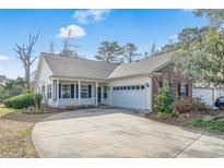 Charming single-story home with a covered porch, two-car garage, and a well-maintained front yard at 10-1 Rattan Circle # 1, Pawleys Island, SC 29585