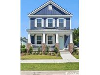 Charming two-story blue home with a welcoming front porch and manicured lawn at 1800 Tryon Dr, Myrtle Beach, SC 29588