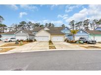 Charming townhomes with well-maintained landscaping, driveways, and attached garages at 2475 Blue Crane Circle # 103, Myrtle Beach, SC 29577