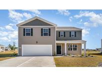 Two-story home with gray siding, a two-car garage, and well-maintained lawn under a bright sky at 348 Rookroost Circle, Conway, SC 29526