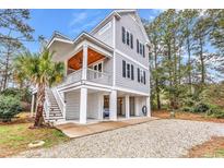 Beautiful coastal home featuring elevated construction and a spacious front porch at 39 Lazy Hammock Trail, Pawleys Island, SC 29585