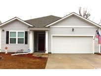 Charming one-story home featuring a well-maintained lawn, attached garage, and inviting front door at 583 Meadowgrass Ct., Myrtle Beach, SC 29588