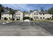View of condo exterior with ample parking and landscaped grounds on a sunny day at 8545 Hopkins Circle # G, Myrtle Beach, SC 29575