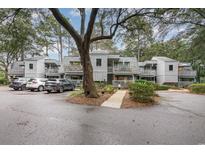 Inviting townhomes feature outdoor balconies and shared parking in a well-maintained, wooded community at 88 Salt Marsh Circle # 22C, Pawleys Island, SC 29585