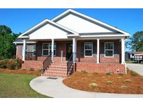 Charming brick home with a inviting front porch, landscaped yard, and black shutters at 960 South Farr Ave., Andrews, SC 29510