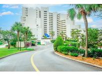 Beautiful exterior shot of a condo building with palm trees and a winding road leading up to the entrance at 101 Ocean Creek Dr. # Jj-1, Myrtle Beach, SC 29572