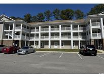 Three story apartment building with multi-car parking and beautiful white railings and balconies at 125 South Shore Blvd. # 201, Longs, SC 29568