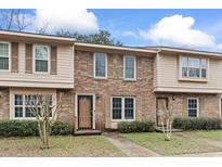 Traditional brick townhome featuring shuttered windows and manicured landscaping on a sunny day at 1409 Highway 15 # 4, Myrtle Beach, SC 29577