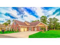 Charming brick home features an attached two car garage, well-manicured lawn, and traditional architectural details at 1796 Fairwinds Dr., Longs, SC 29568