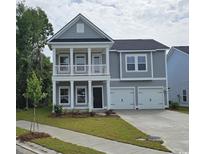 Charming two-story home showcasing a covered front porch and a two-car attached garage at 1808 Sunshine Ct., North Myrtle Beach, SC 29582