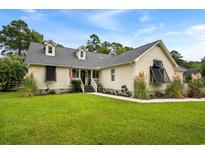 Charming single-Gathering home featuring a well-manicured lawn and inviting front porch at 2264 Wedgefield Rd., Georgetown, SC 29440