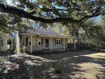 Charming single-story home with a welcoming front porch and lush, mature trees at 402 Wilkinson St., Georgetown, SC 29440